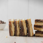straight on view of the caramel chocolate shortbread bars stacked on their sides
