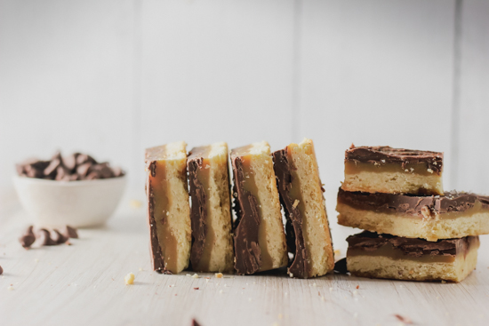 straight on view of the caramel chocolate shortbread bars stacked on their sides