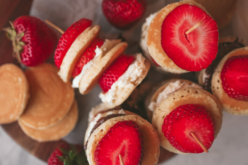 Strawberry Nutella pancake skewers stacked on a stick with fresh strawberry slices