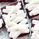 overhead view of a brownie topped with white frosting swoops to look like a mummy
