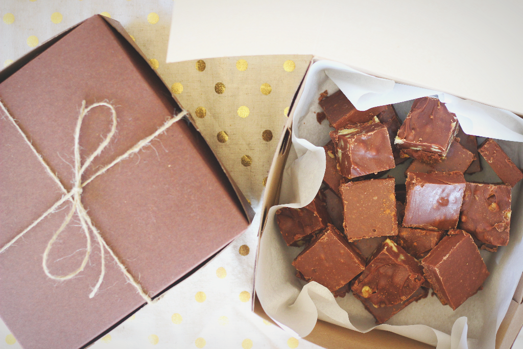 homemade chocolate fudge with marshmallow fluff next to a gift box