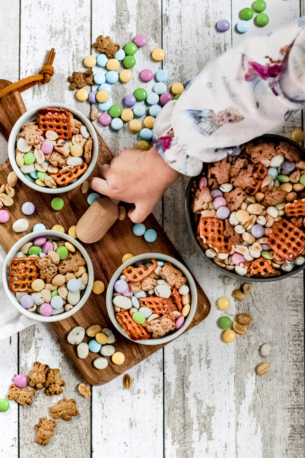 Overhead view of bunny bait in bowls with a tiny kid hand reaching to grab some