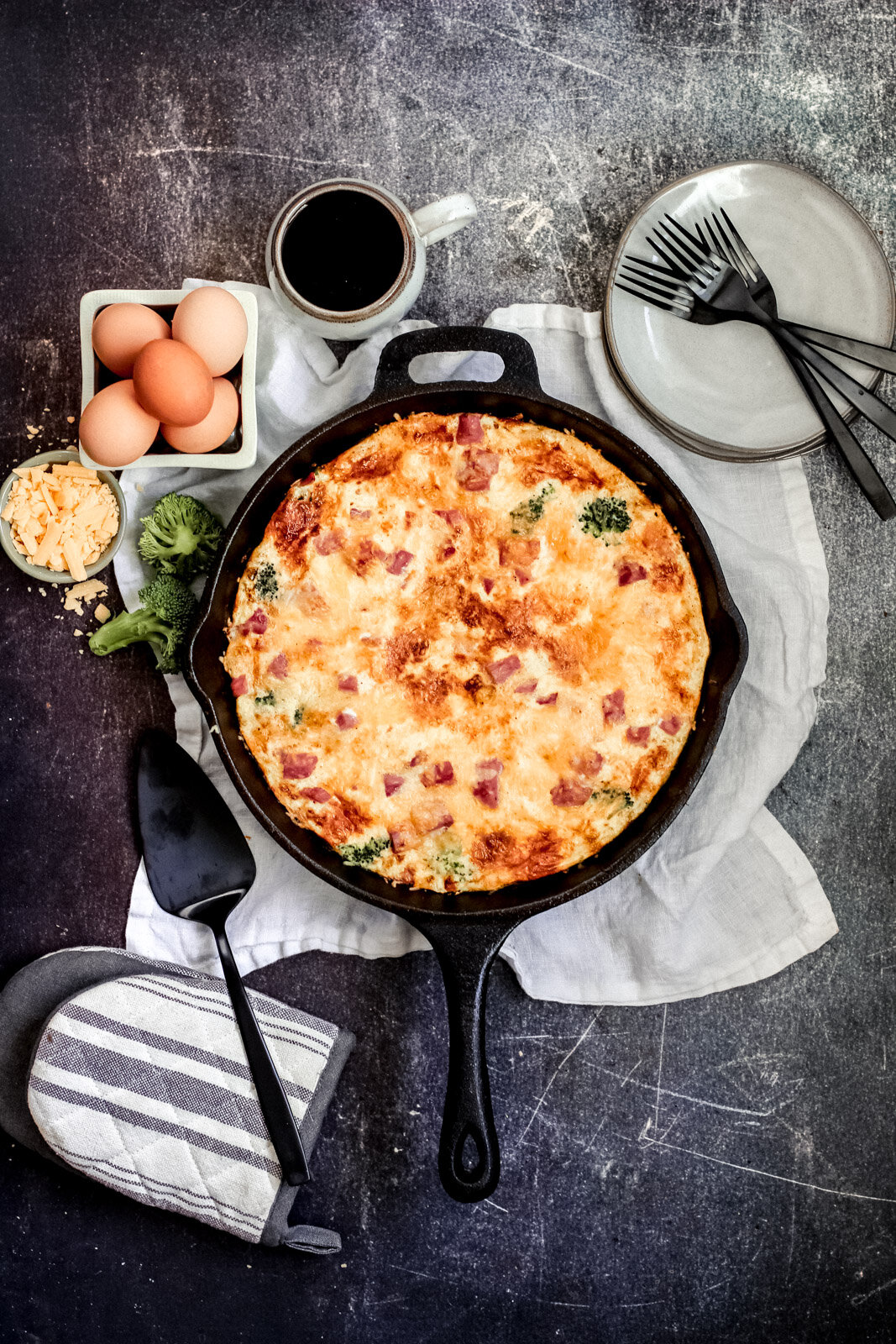 Egg Frittata in a cast iron pan with plates and utensils