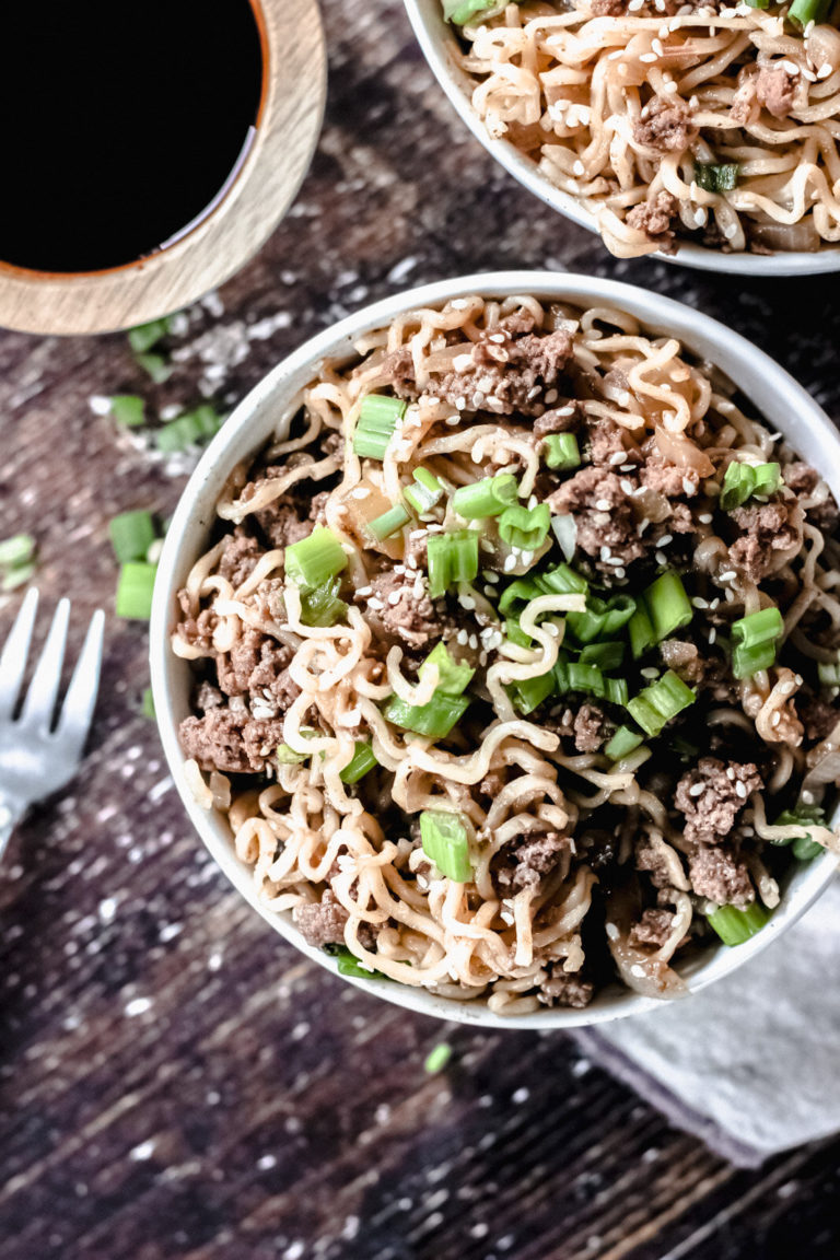overhead view of a bowl of noodles and ramen broth