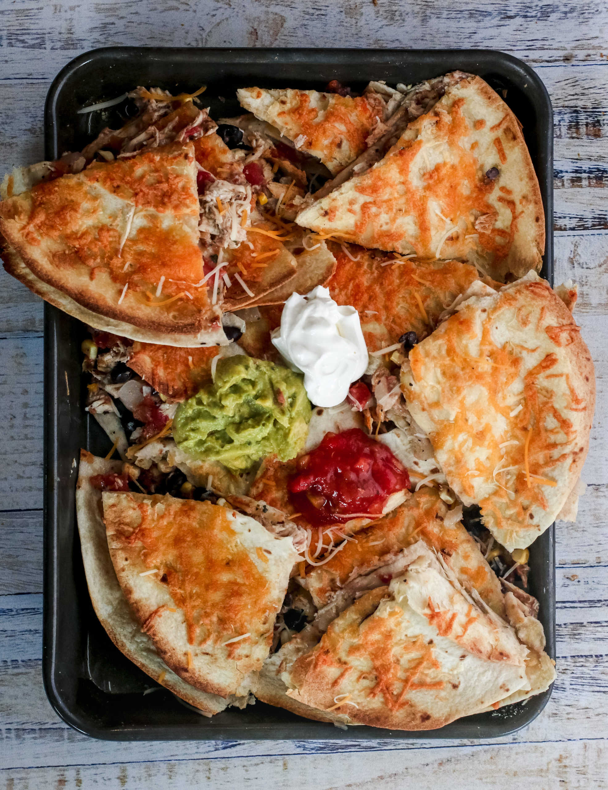 overhead view of sheet pan quesadillas with toppings