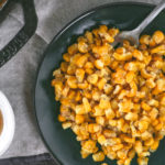 Overhead view of a skillet filled with creamy honey corn. 
