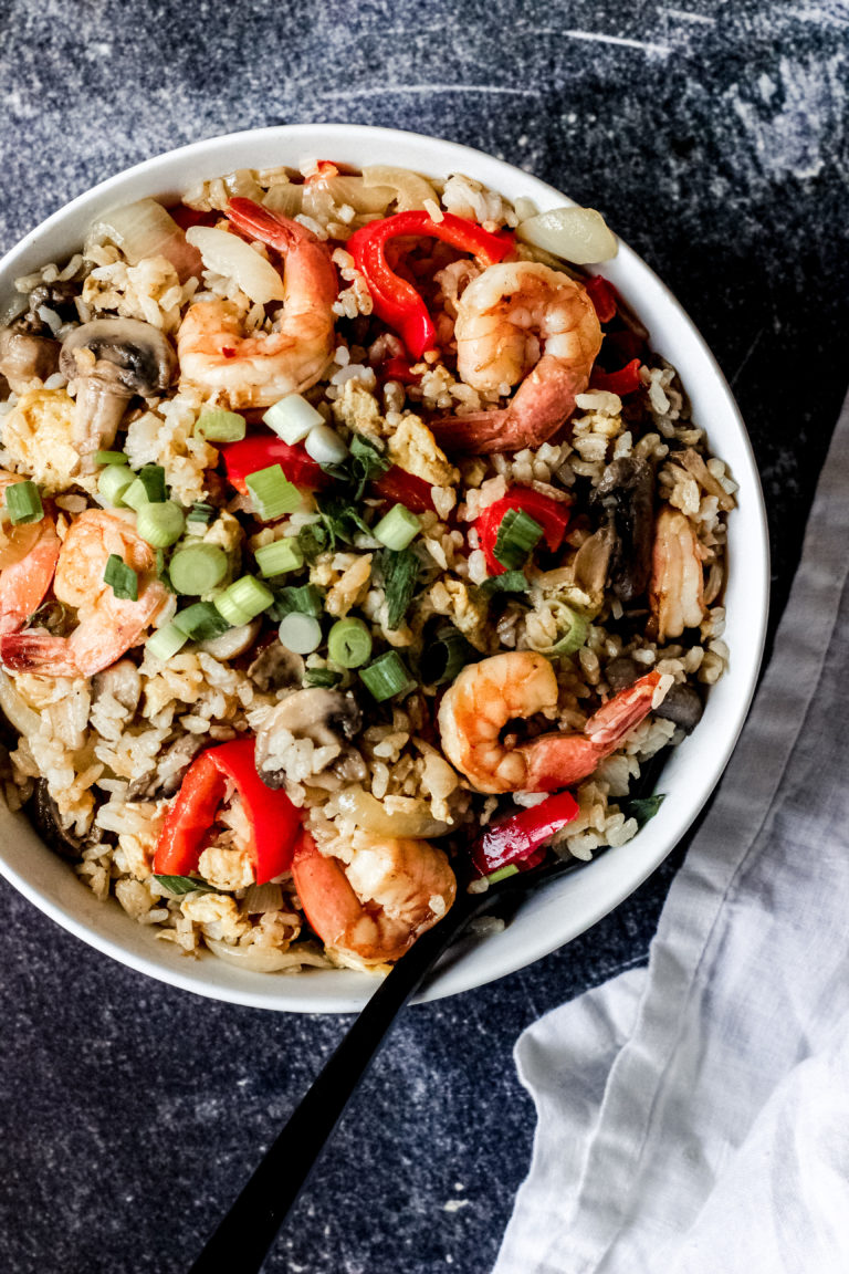 Overhead look at a bowl filled with skillet cooked shrimp, veggies and rice