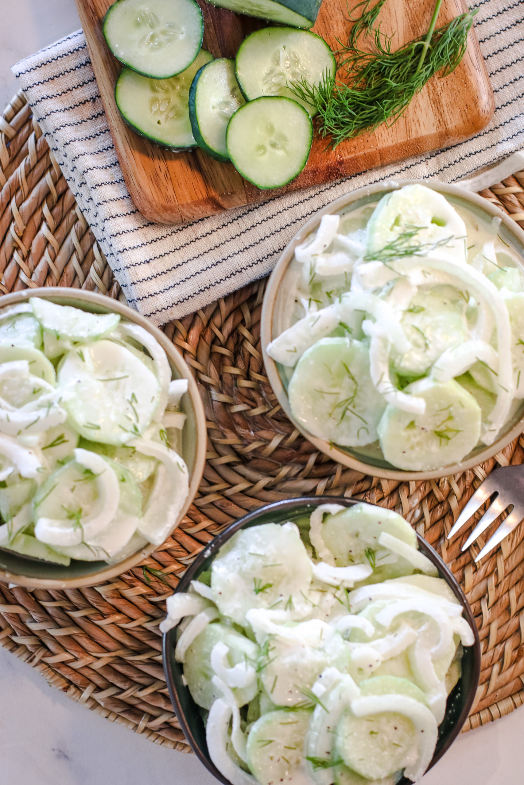 overhead view of a bowl nof creamy cucumber salad and onions