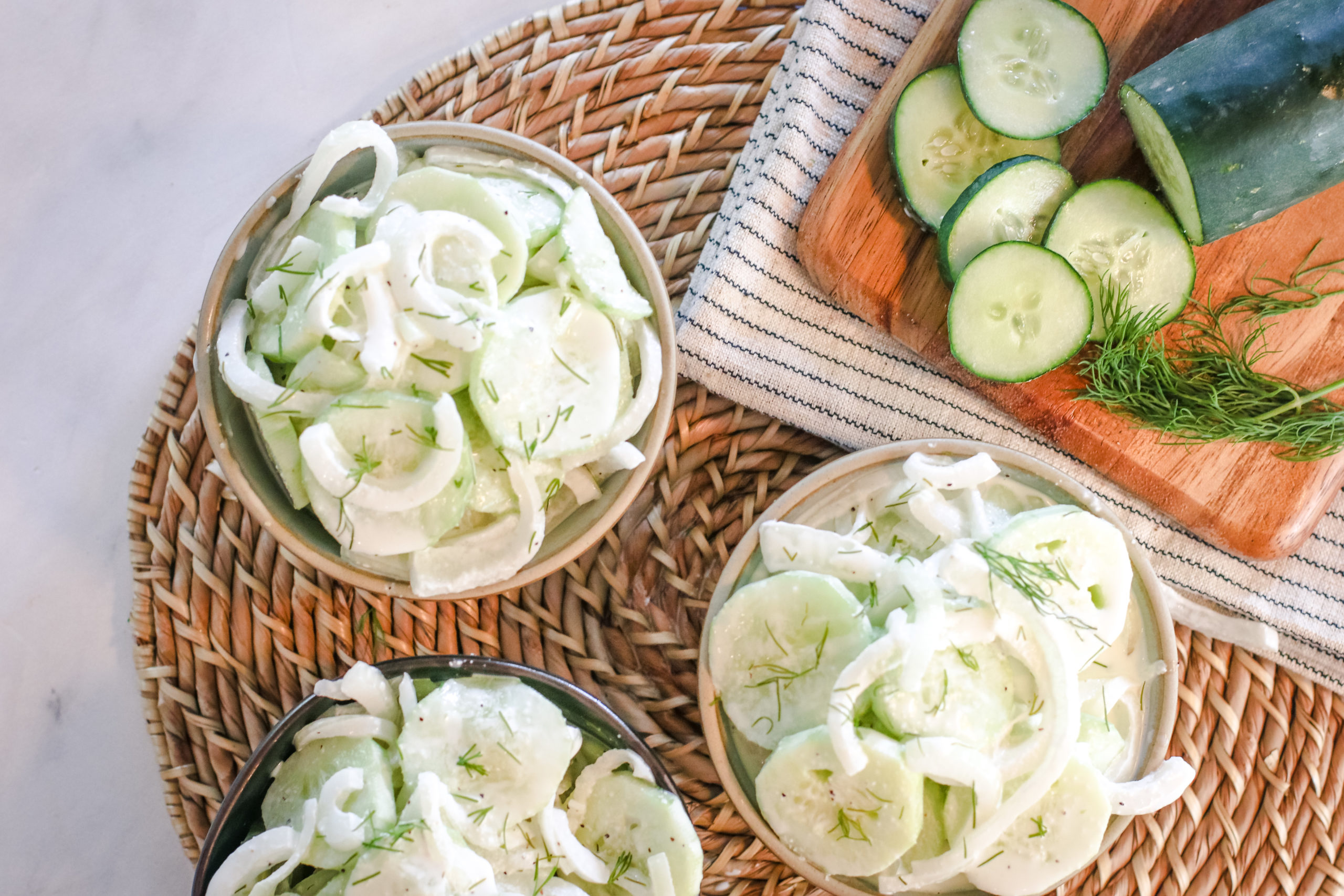 overhead view of a bowl nof creamy cucumber salad and onions