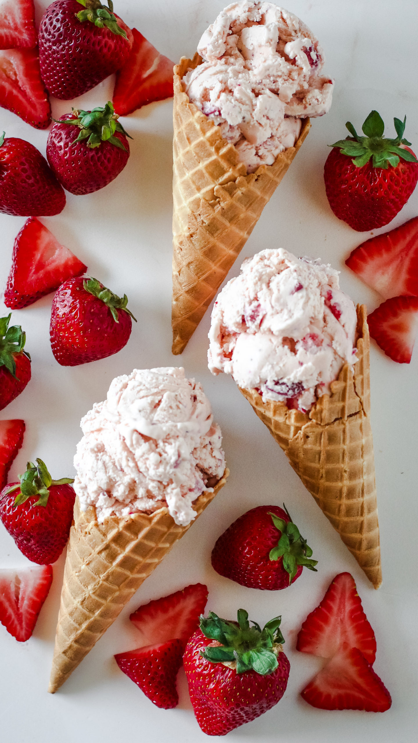 overhead view of strawberry ice cream in waffle cones