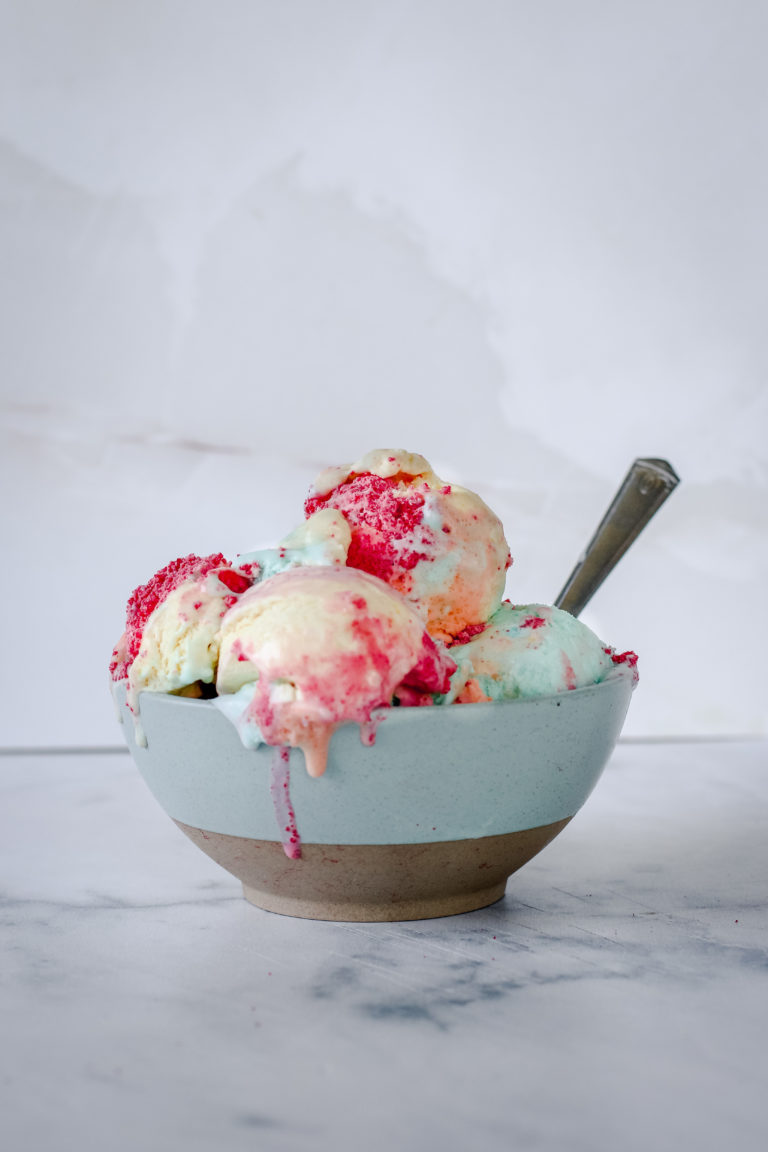 straight on view of a bowl of rainbow colored ice cream
