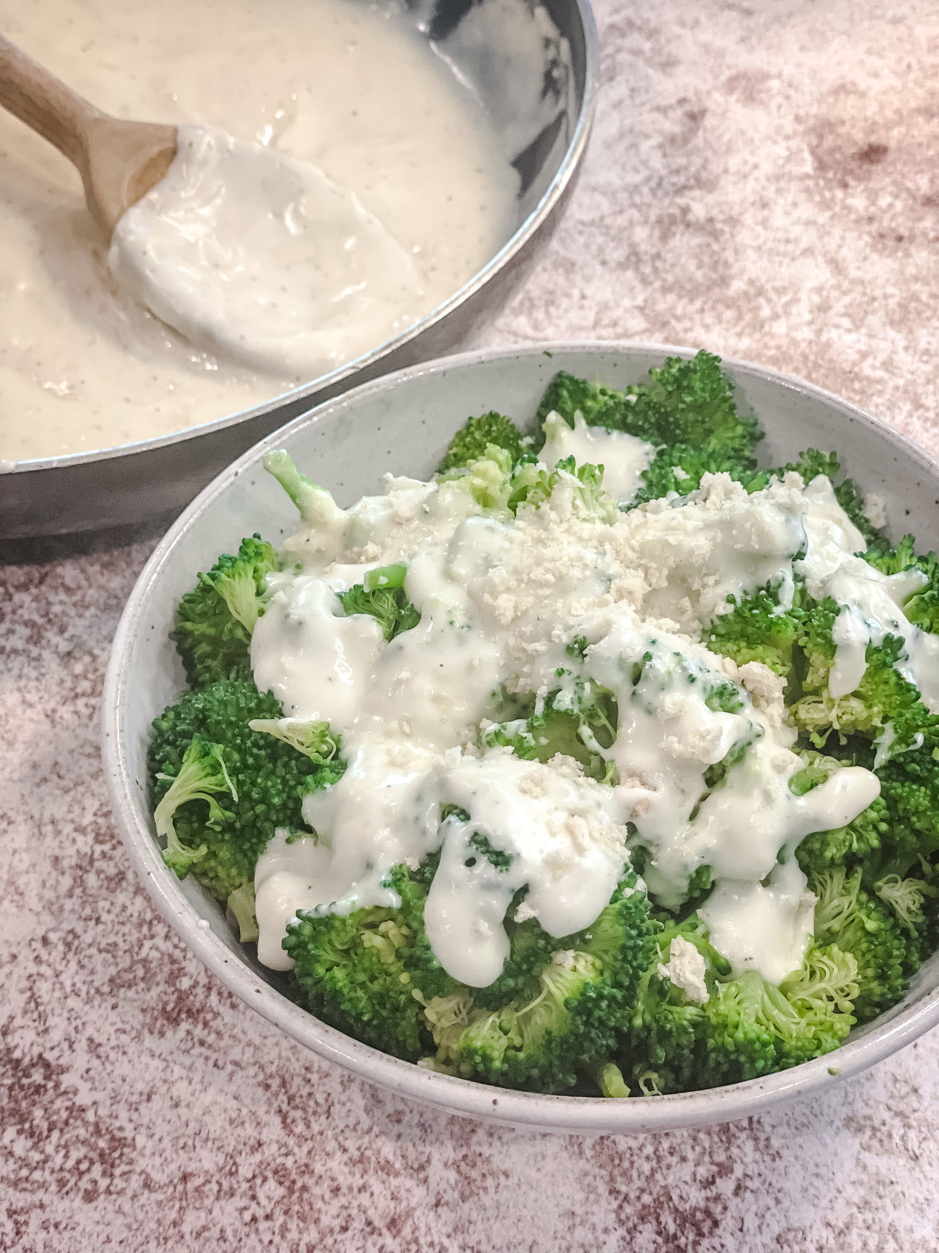 overhead shot of broccoli with the creamy parmesan sauce drizzled over