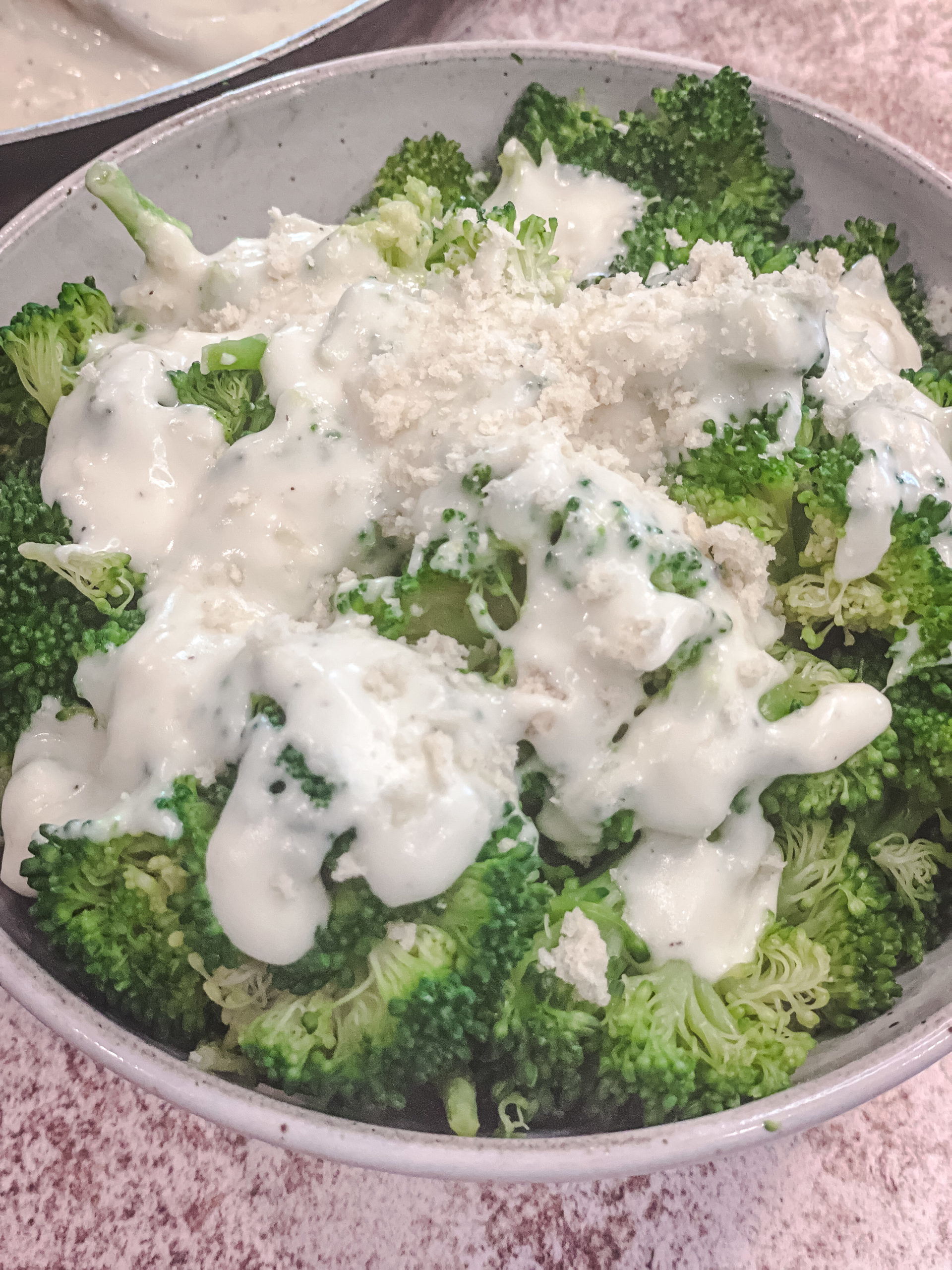 overhead shot of broccoli with the creamy parmesan sauce drizzled over
