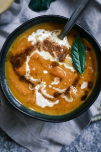 overhead view of creamy pumpkin soup with vanilla brown butter drizzle