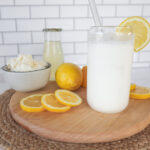 front view of a cup of creamy lemonade, lemon slices and ice cream.
