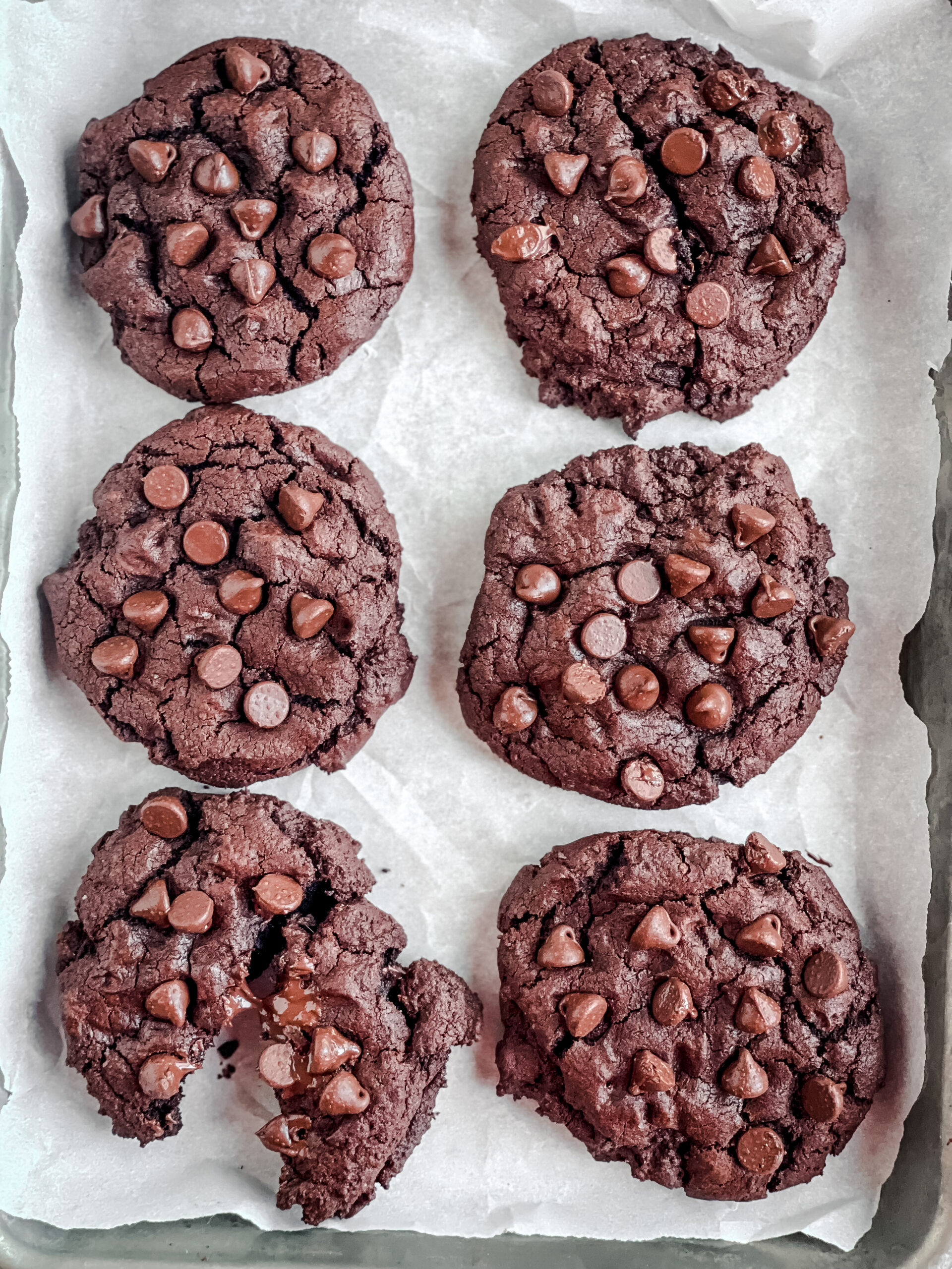 overhead view of a pan of chocolate cookies with melted chocolate chips on top