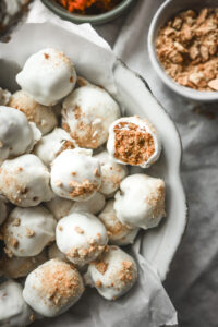 Overhead shot of a bowl of pumpkin spice truffles covered in white chocolate
