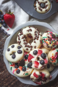 Overhead look at a plate of pancake donuts with fruit and sprinkles