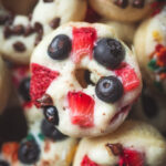 Overhead look at a plate of pancake donuts with fruit and sprinkles