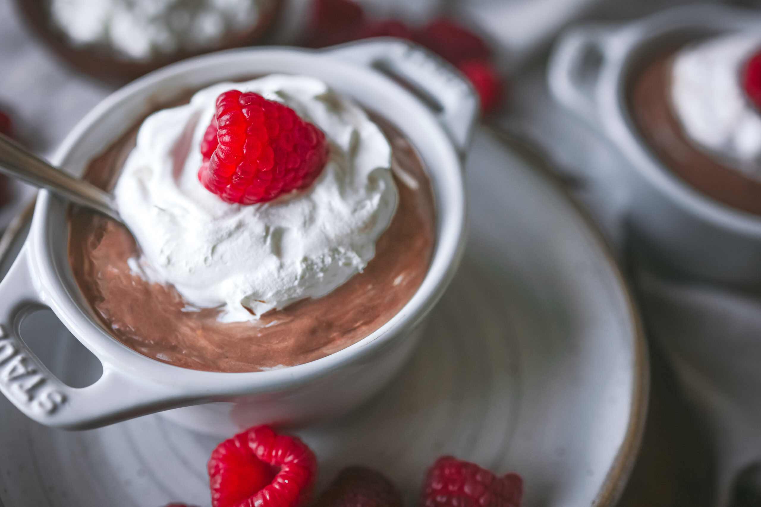 Jar of cottage cheese chocolate mousse with whipped cream and raspberries