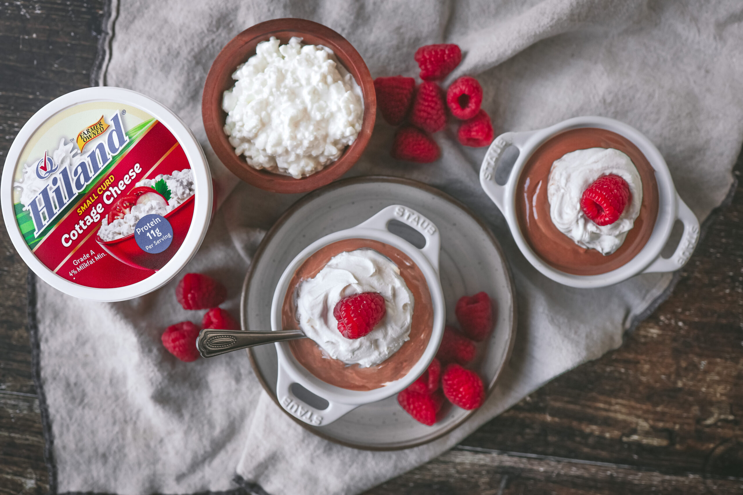 Jar of cottage cheese chocolate mousse with whipped cream and raspberries