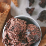 Scoop of rich and creamy no churn chocolate fudge brownie ice cream with chunks of brownie in a white bowl