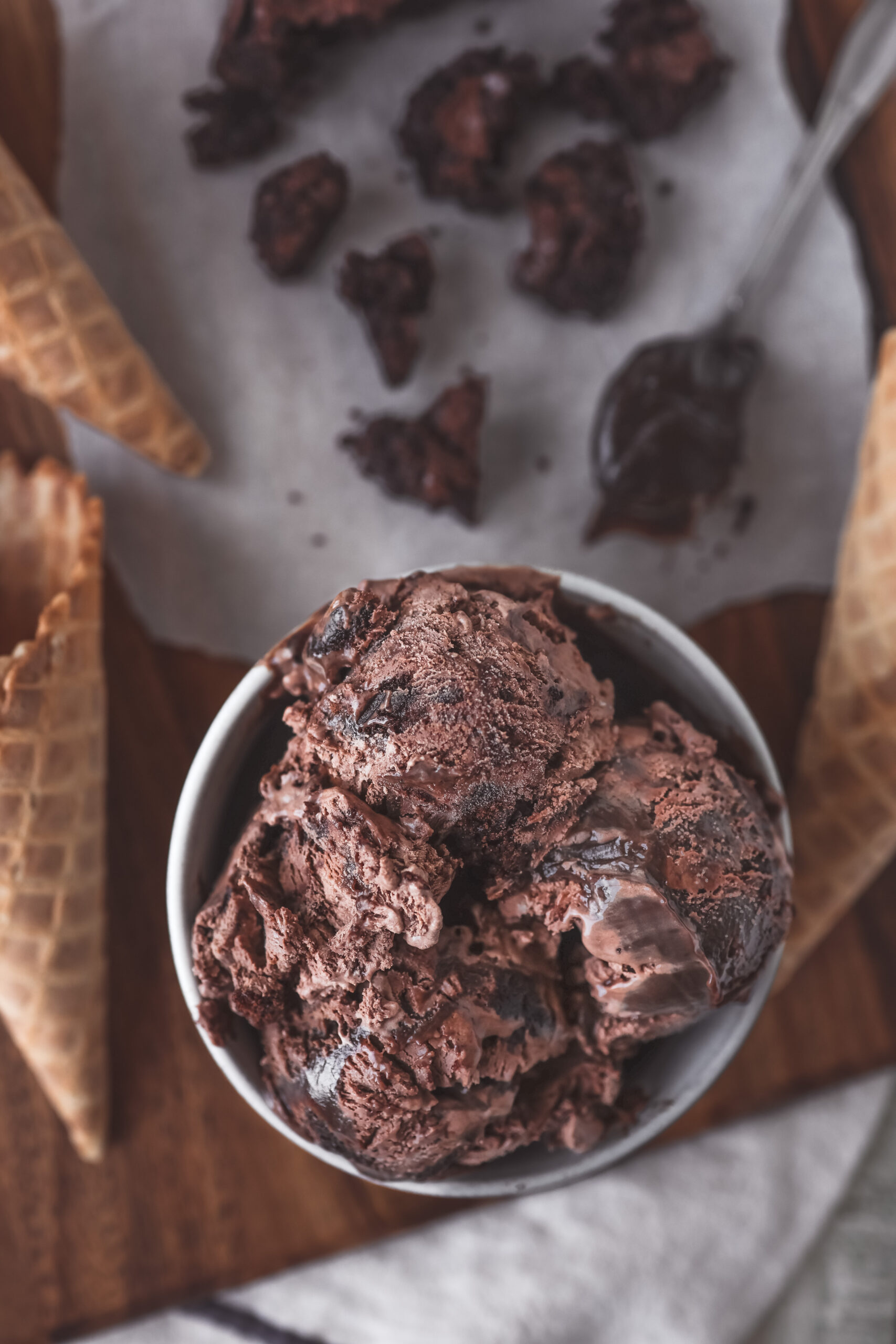 Scoop of rich and creamy no churn chocolate fudge brownie ice cream with chunks of brownie in a white bowl.