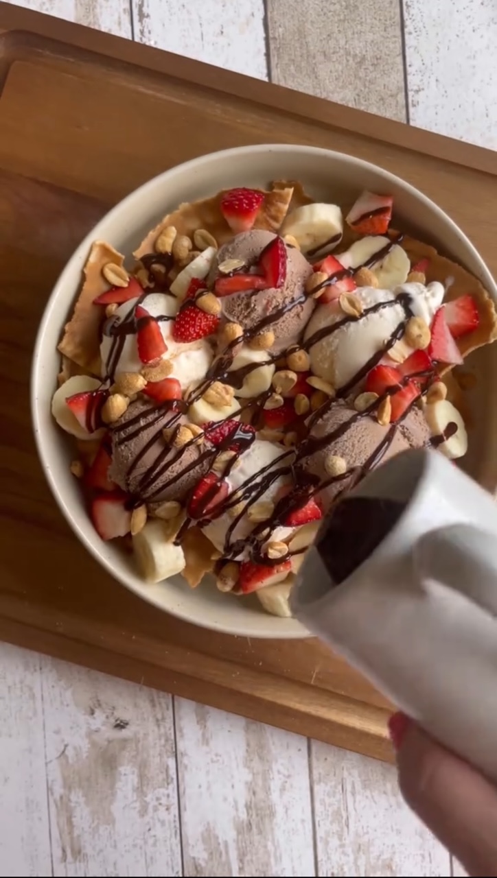 Ice Cream Nachos topped with bananas, strawberries, chocolate syrup, sprinkles and whipped cream.