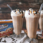 straight on photo of milkshake glasses filled with cold brew milkshake and topped with whipped cream