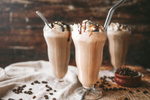 straight on photo of milkshake glasses filled with cold brew milkshake and topped with whipped cream