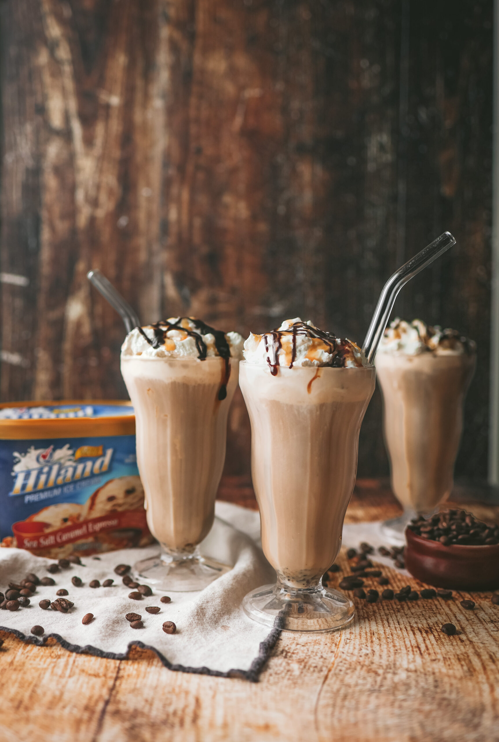 straight on photo of milkshake glasses filled with cold brew milkshake and topped with whipped cream