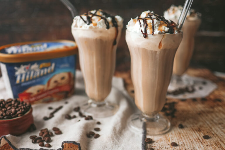 straight on photo of milkshake glasses filled with cold brew milkshake and topped with whipped cream