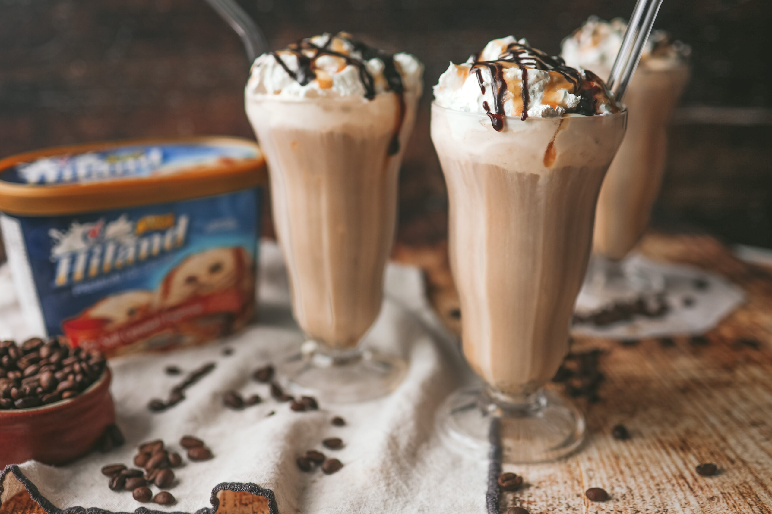 straight on photo of milkshake glasses filled with cold brew milkshake and topped with whipped cream
