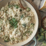 Overhead shot of creamy chicken, broccoli, and orzo in a skillet