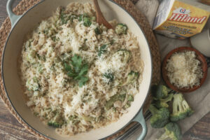 Overhead shot of creamy chicken, broccoli, and orzo in a skillet