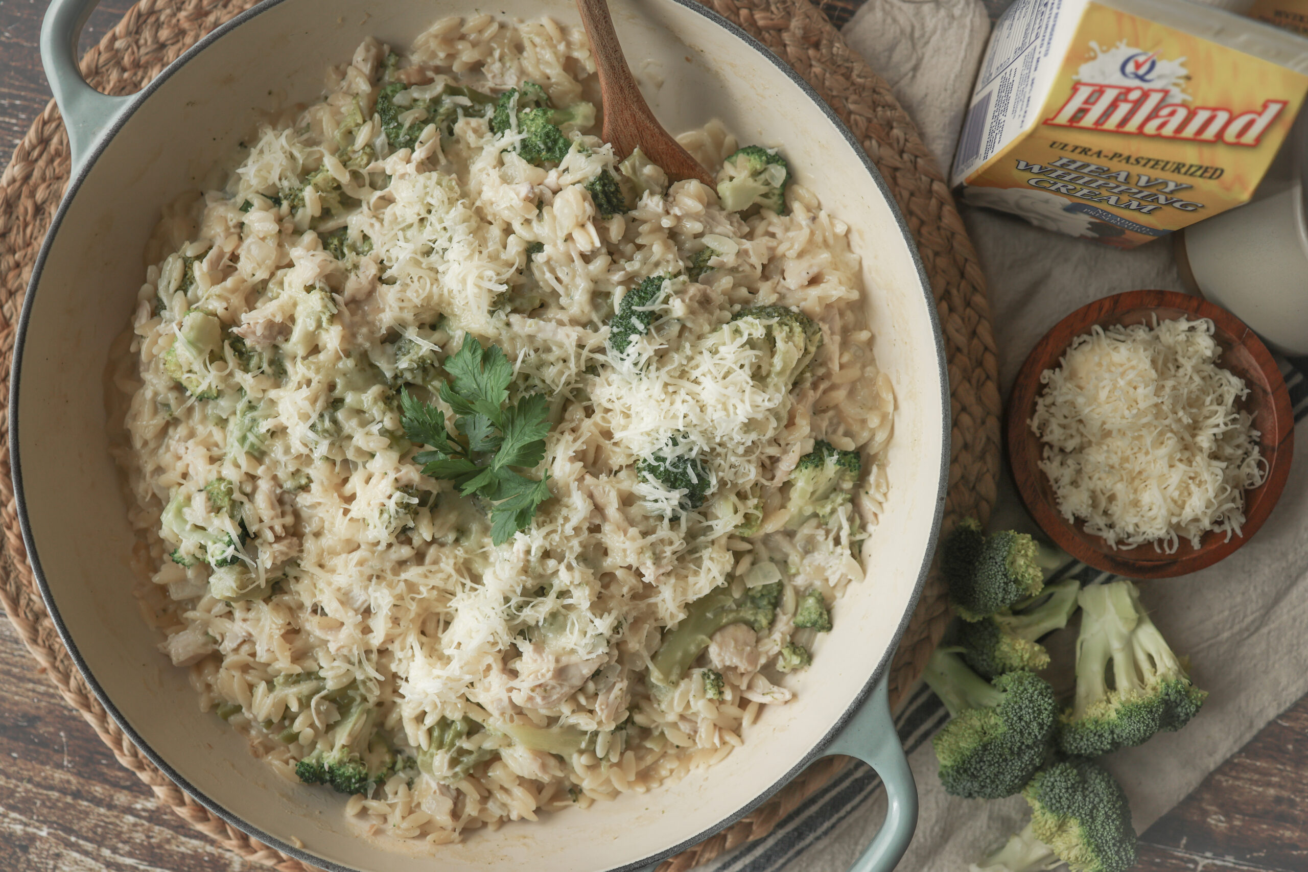 Overhead shot of creamy chicken, broccoli, and orzo in a skillet