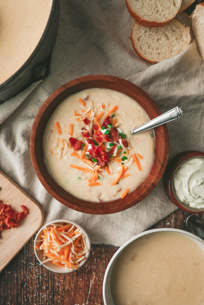 Overhead look at a bowl of creamy potato soup with bacon, chives and cheese