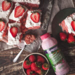Overhead look at a strawberry cake with a strawberry milk tres leches sauce over top
