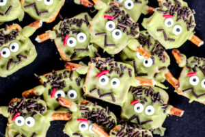 Make spooky and fun Frankenstein Pretzels for Halloween! Easy chocolate-dipped pretzel with candy eyes and silly monster faces kids will love.