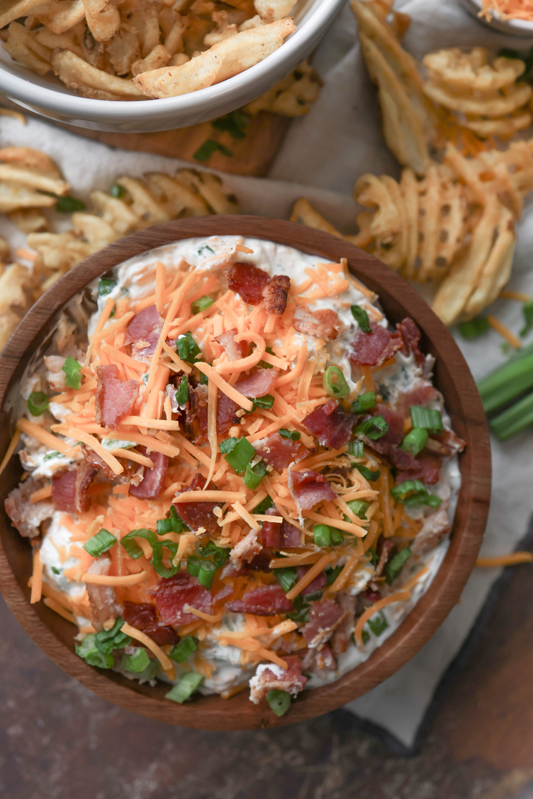 Loaded baked potato dip made with sour cream, cheddar cheese, bacon, and chives