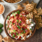 Loaded baked potato dip made with sour cream, cheddar cheese, bacon, and chives