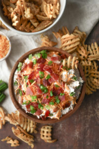 Loaded baked potato dip made with sour cream, cheddar cheese, bacon, and chives