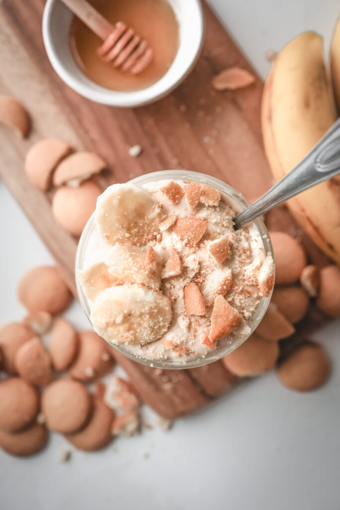 Overhead look of a jar filled with cottage cheese banana pudding and topped with nilla wafers and bananas