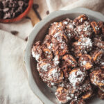 Bowl of Peanut Butter Ritz Cracker Puppy Chow dusted with powdered sugar