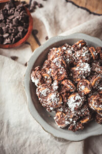 Bowl of Peanut Butter Ritz Cracker Puppy Chow dusted with powdered sugar