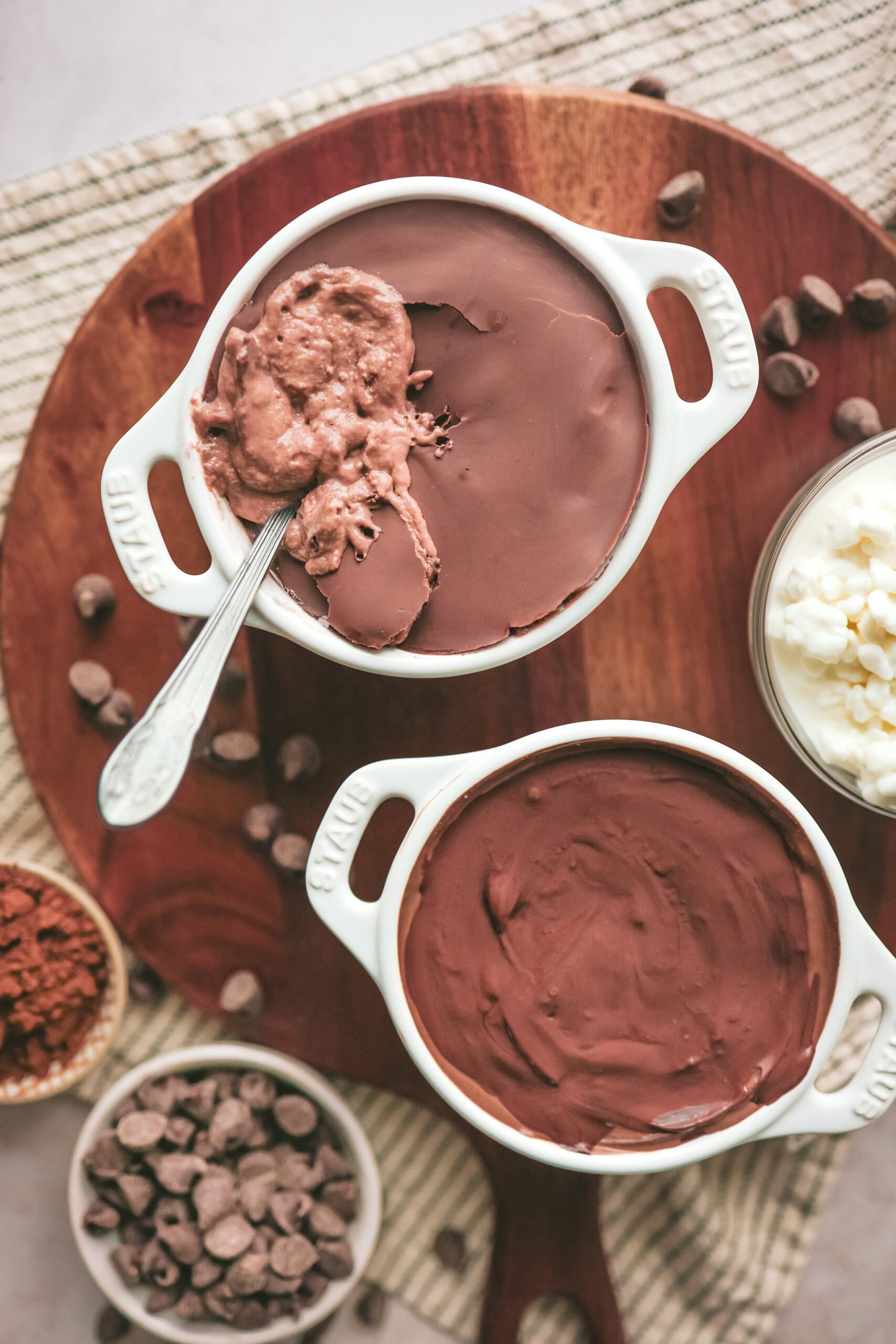 A small bowl of chocolate protein cheesecake with a cracked chocolate shell on top, revealing a creamy cocoa filling underneath.