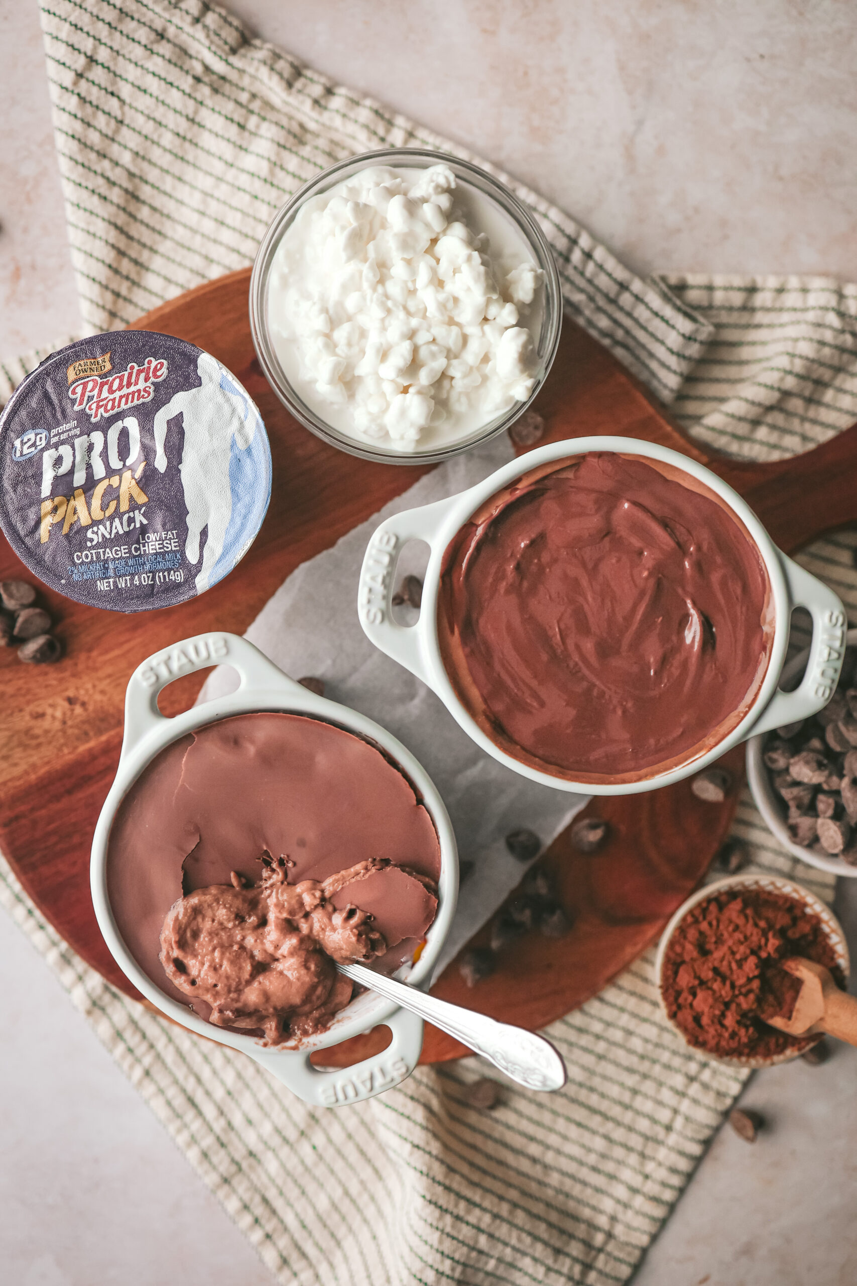 A small bowl of chocolate protein cheesecake with a cracked chocolate shell on top, revealing a creamy cocoa filling underneath.