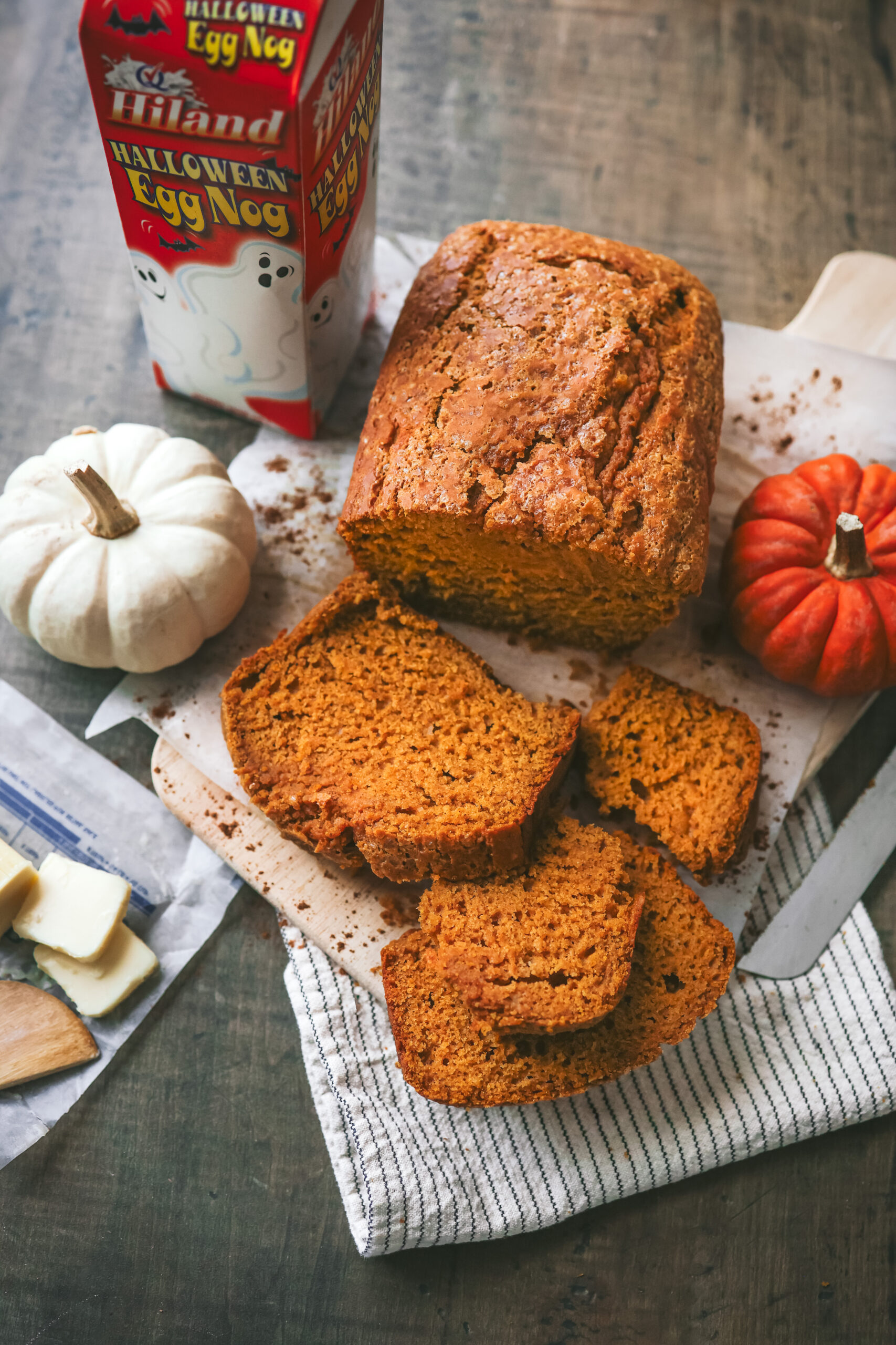 Slices of homemade pumpkin eggnog bread showing a moist, tender texture and warm pumpkin color, perfect for fall baking.