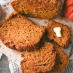 Slices of homemade pumpkin eggnog bread showing a moist, tender texture and warm pumpkin color, perfect for fall baking.