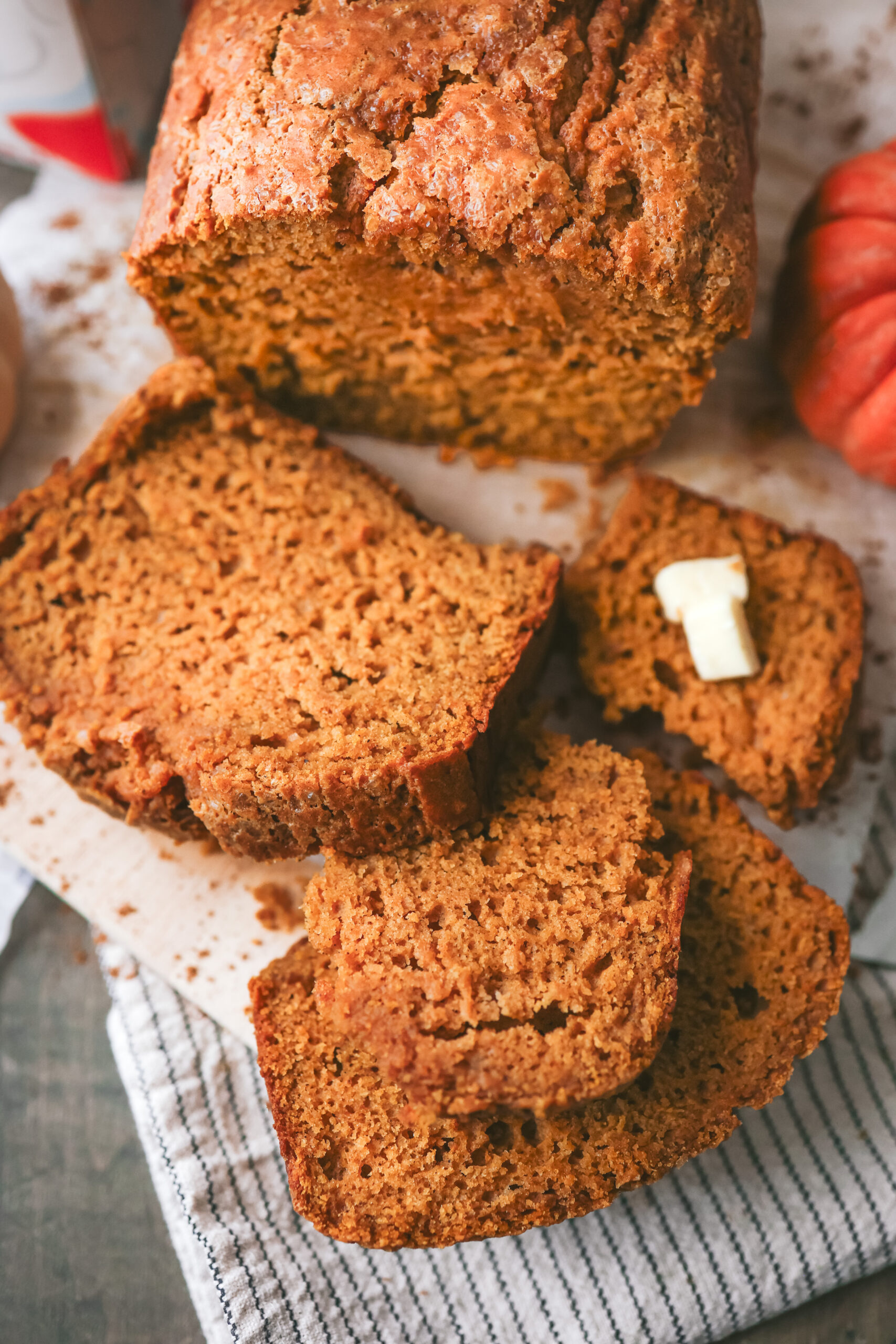 Slices of homemade pumpkin eggnog bread showing a moist, tender texture and warm pumpkin color, perfect for fall baking.